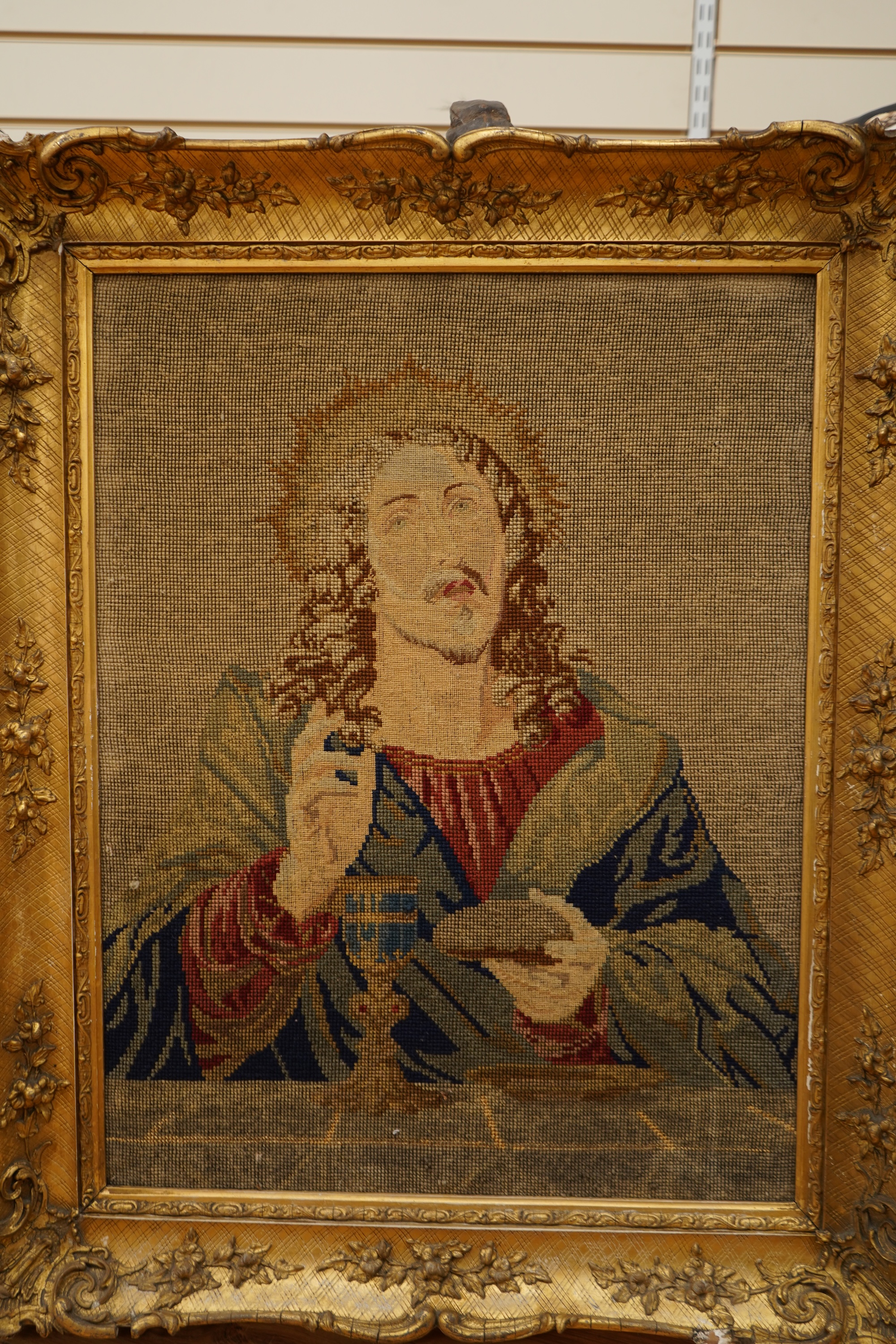 Two Victorian woolwork embroideries, one depicting Christ, the other John the Baptist both in carved gilt frames, largest 82cm high x 66cm wide
